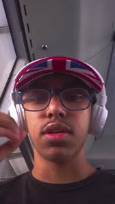 Profilfoto eines jungen Mannes mit Brille, britischer Flaggen-Mütze und Kopfhörern
